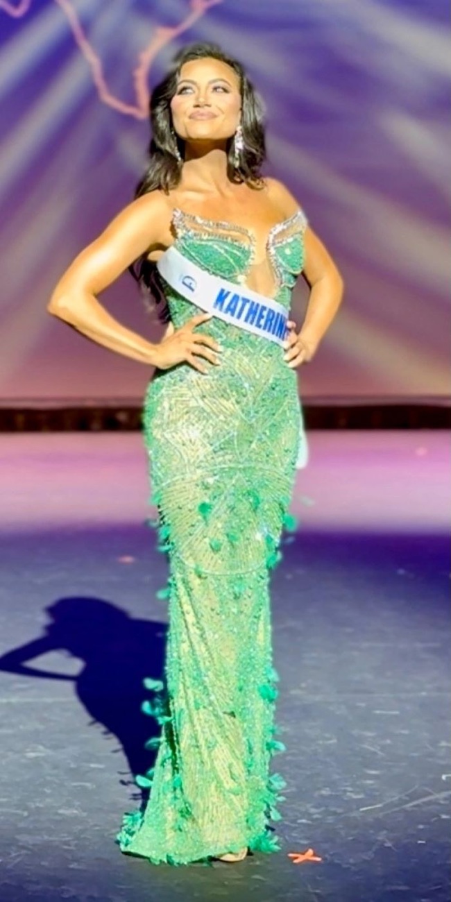 Client on the pageant stage in an evening gown, dialed in for competition.